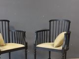 pair of black chairs with yellow cushions against a gray wall