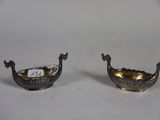 pair of silver plated bowls with handles on a white surface