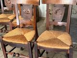 four wooden chairs sitting next to each other on a tiled floor