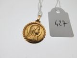 un gros plan sur un collier en or orné d'une image représentant une femme
