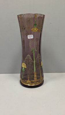 un vase violet orné de fleurs jaunes, posé sur une table