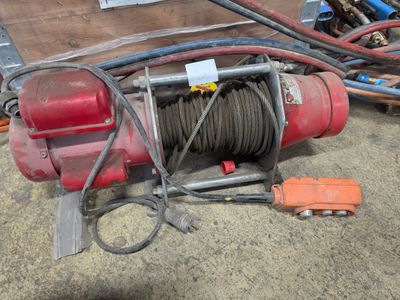 une image représentant un treuil rouge auquel est attachée une corde