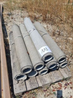 a pile of pipes sitting on the ground next to a pile of wood