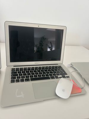 un ordinateur portable posé sur un bureau, avec une souris et un tapis de souris