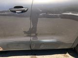 a car that has a broken door handle on the side of the road