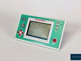 une Game Boy verte et blanche posée sur une surface blanche