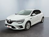 Une voiture blanche est garée dans une pièce au sol noir.
