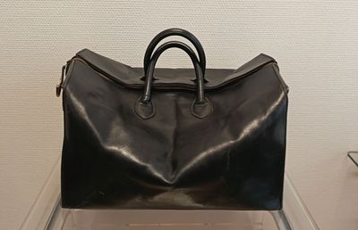 un sac noir posé sur une table en verre