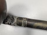 a pipe with a metal handle on a white surface