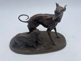 statue en bronze représentant un chien et un chat, posée sur un plateau
