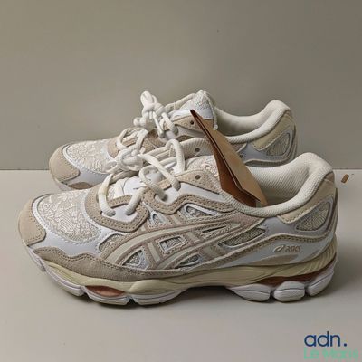 La chaussure est blanche et possède une semelle marron.