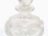 une bouteille en verre transparent ornée d'une fleur sur le goulot