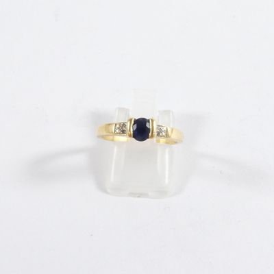 gros plan d'une bague en or avec une pierre noire