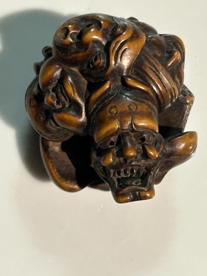 a small statue of a monkey with a skull on it ' s head