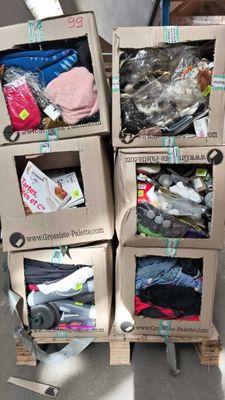 Plusieurs cartons sont empilés les uns sur les autres dans une pièce