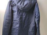 the back of a blue jacket hanging on a hanger on a wall