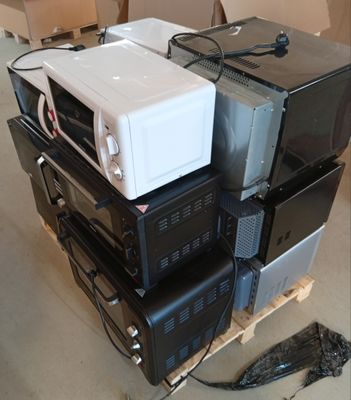 une pile de fours à micro-ondes posée sur une palette