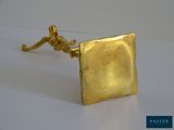 a gold plated cuff with a man sitting on it