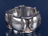 gros plan d'un bracelet en argent sur une surface noire