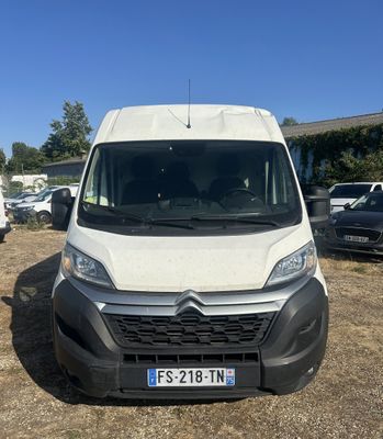 a white van parked in a parking lot next to other cars