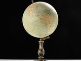 a small globe that is on a stand on a table