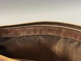 the inside of a brown leather purse with a gold zipper