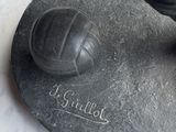 a statue of a soccer ball on a stone base