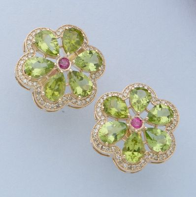 paire de boucles d'oreilles en forme de fleur, composées de péridot et de diamants, sur un fond blanc