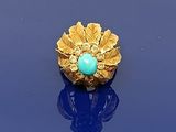 une image représentant une bague en or ornée d'une pierre turquoise au centre
