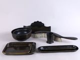un assortiment de plats et de pinceaux noirs et dorés sur fond blanc