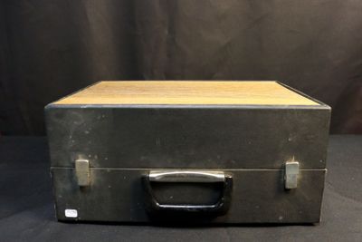 an old metal box with a wooden handle on a black background