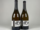 two bottles of wine sitting next to each other on a table