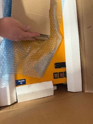 a person that is opening a box with a cell phone in it