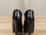 a pair of black high heeled shoes sitting on top of a wooden table