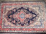 a close up of a rug on a floor with a red and blue rug