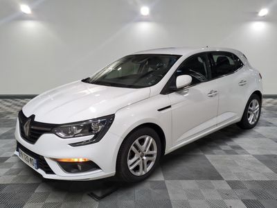 une voiture blanche garée dans une pièce au sol en damier