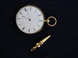 a small gold pocket watch with a chain attached to it