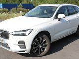 the white volvo suv is parked on the side of the road