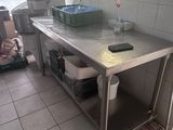 a kitchen with a stainless steel table and a mirror