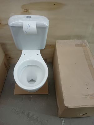 a white toilet sitting next to a cardboard box