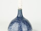 a blue and white vase with a light on top of it