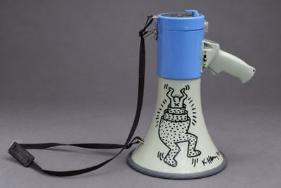 un mégaphone bleu et blanc muni d'une sangle noire