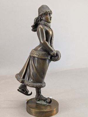 bronze figurine of a girl with a basket of flowers
