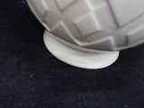 a white vase sitting on top of a black table