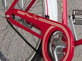 a red and white bicycle parked in front of a building