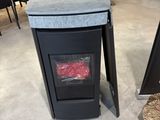 une poubelle noire posée par terre à côté d'une table