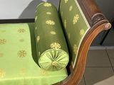 a wooden bench with a green cushion on top of it