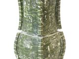 un vase vert orné de sculptures sur fond blanc