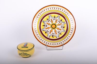une assiette jaune et un vase jaune posés sur une surface blanche