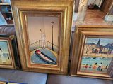 trois photos encadrées représentant des bateaux, posées sur un canapé dans un salon